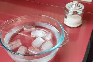 Un recipiente con agua, hielo y unas cucharadas de sal